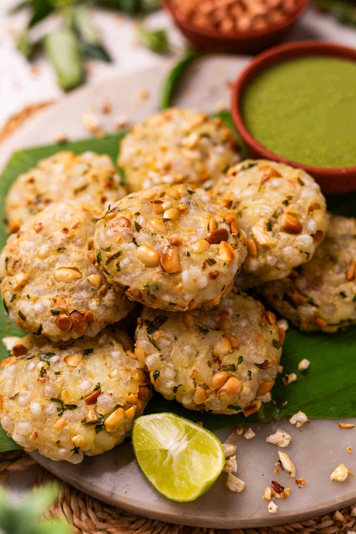 An image of hot and crispy air fryer sabudana vadas placed on a leaf platter and served with green chutney