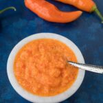 Aji Amarillo Paste with peppers around the bowl