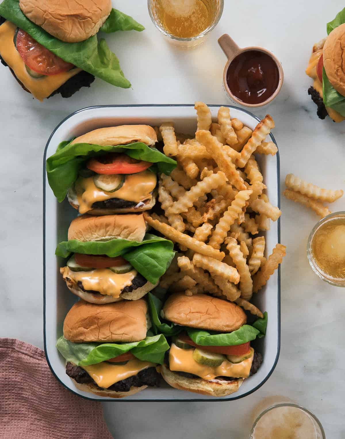 Smash Burgers with crinkly fries and a side of ketchup.