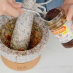 Thai chili paste being spooned into a mortar