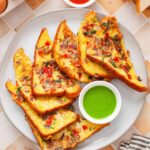 Indian french toast served on a white plate with green chutney.