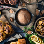 large black bowl of spice rub, surrounded by different foods on dishes