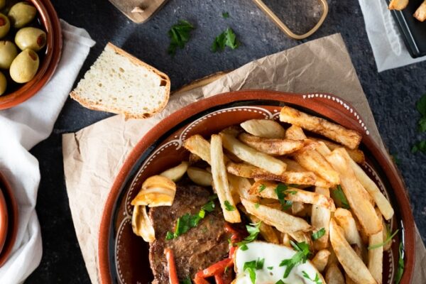 Azores-Style Regional Steak (Bife à Regional) Red plate with steak, fries and an egg