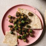 Partially eaten plate of Bhindi Fry with roti.
