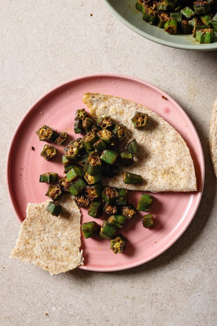 Partially eaten plate of Bhindi Fry with roti.