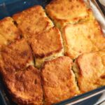 a square glass pan of butter swim biscuits cut into 9 servings.