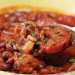 closeup of frijoles charros on spoon