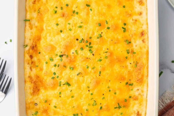 Cheesy Mashed Potatoes – Cookin’ with Mima A casserole dish filled with a cheesy mashed potatoes recipe.