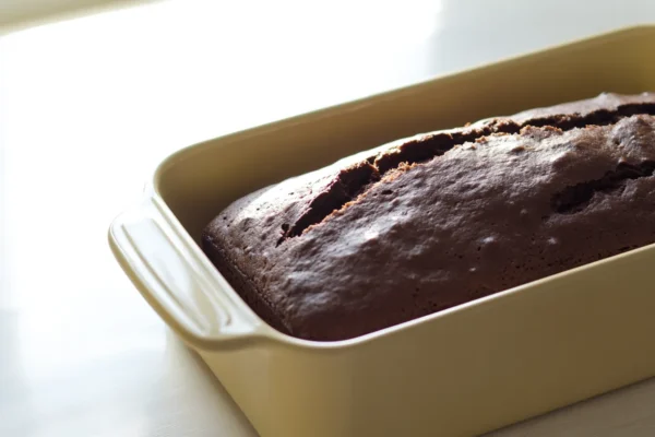 Freshly baked chocolate bread loaf in a pan, ready to be sliced.
