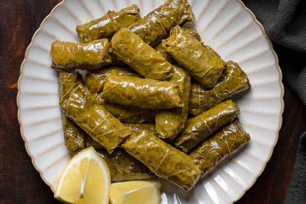 Dolmades: Greek Stuffed Grape Leaves with Rice Dolmades, Greek stuffed grape leaves with rive on a plate. Featured.