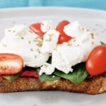 Beet Hummus on Toast with cheese and sliced cherry tomatoes
