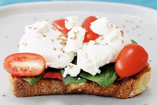 Beet Hummus on Toast with cheese and sliced cherry tomatoes
