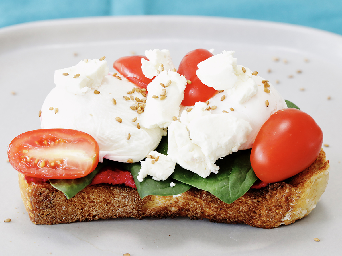 Beet Hummus on Toast with cheese and sliced cherry tomatoes