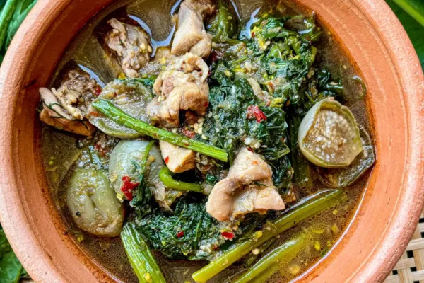 Gaeng om gai, a Northeastern Thai chicken and herb soup, complete with sticky rice in a bamboo container.