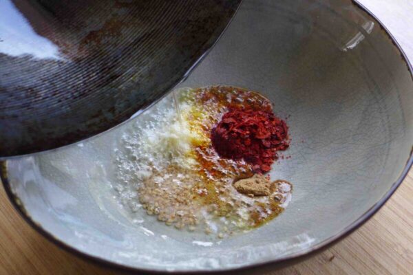 Hot and Sour Noodles (Suan La Mian, Sour Noodles) pouring oil over spices.