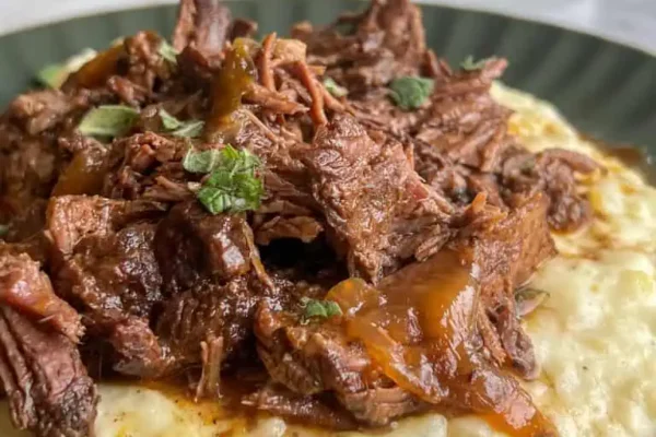 Braised Chuck Roast (Fall Apart Tender) Braised chuck roast on top of creamy mashed potatoes