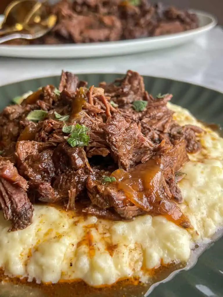 Braised chuck roast on top of creamy mashed potatoes