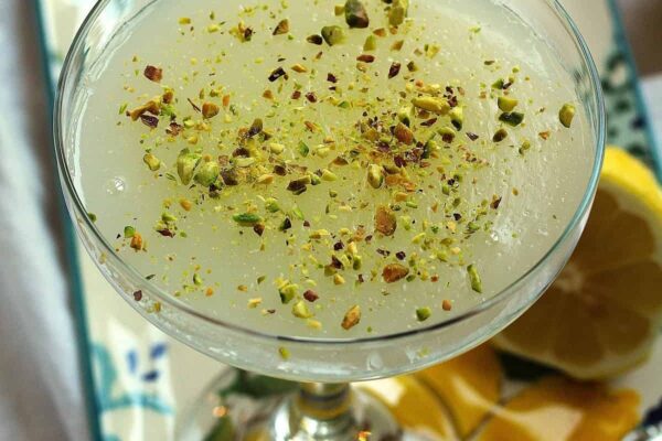 Sicilian gelo di limone, lemon pudding, topped with pistachios in glass.