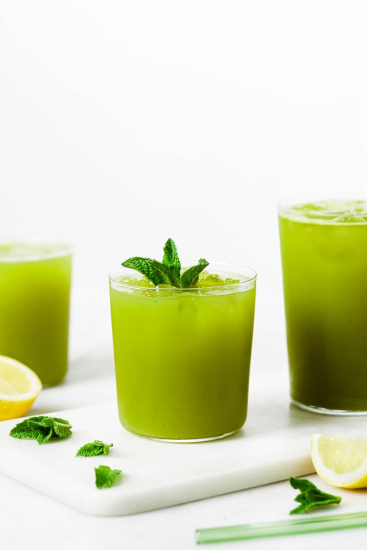 Mint Lemonade (Desi Restaurant-Style) – Tea for Turmeric Three glasses of green juice with mint leaves