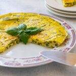 asparagus frittata on a platter garnished with basil leaves