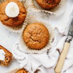banana bread muffins on a counter next to a knife