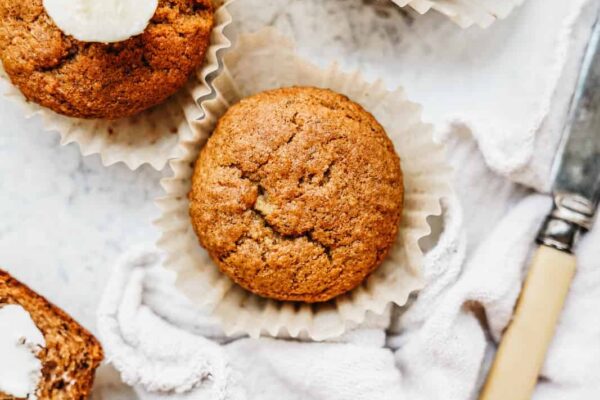 banana bread muffins on a counter next to a knife
