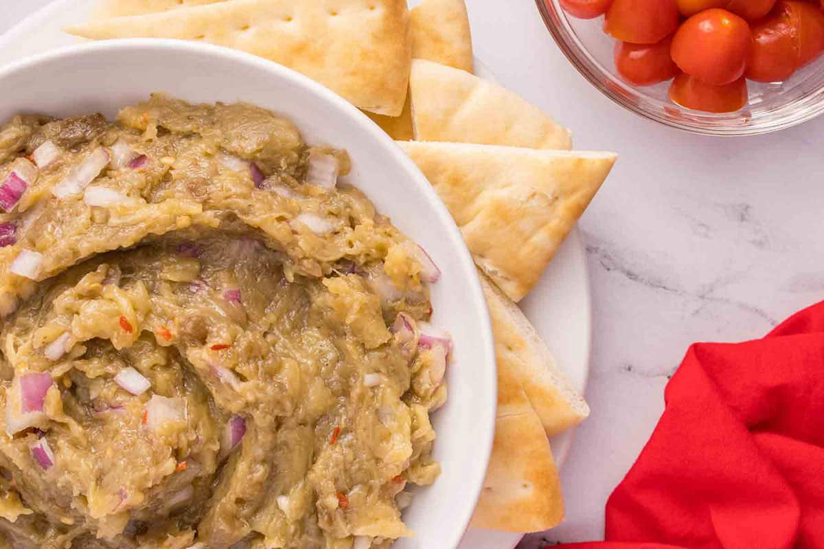 bowl of roasted eggplant dip surrounded by pita chips