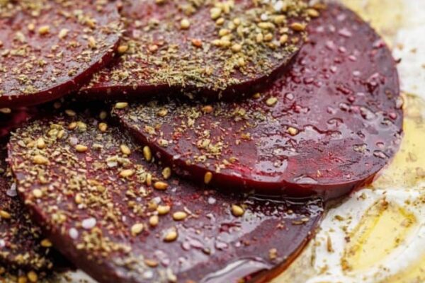 Roasted beet salad with labneh and za'atar sprinkled on top, and drizzled in olive oil.