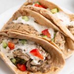 Chicken gyros pitas on a white platter.