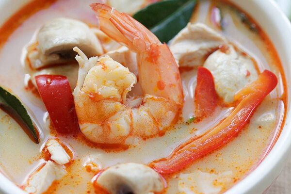 Tom Kha soup with chicken and shrimp in a creamy coconut broth served in a bowl.