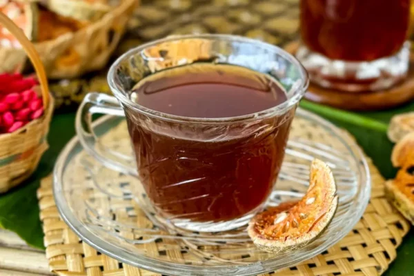 A cup of bael tea and a tall glass of chilled bael juice.