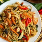 Thai drunken spaghetti seafood, spaghetti kee mao, served in a white dish.