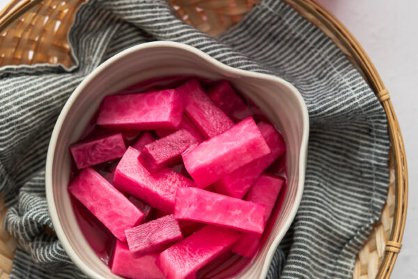 Korean Pink Pickled Radish -Beyond Kimchee Pink pickled radish in a serving dish.