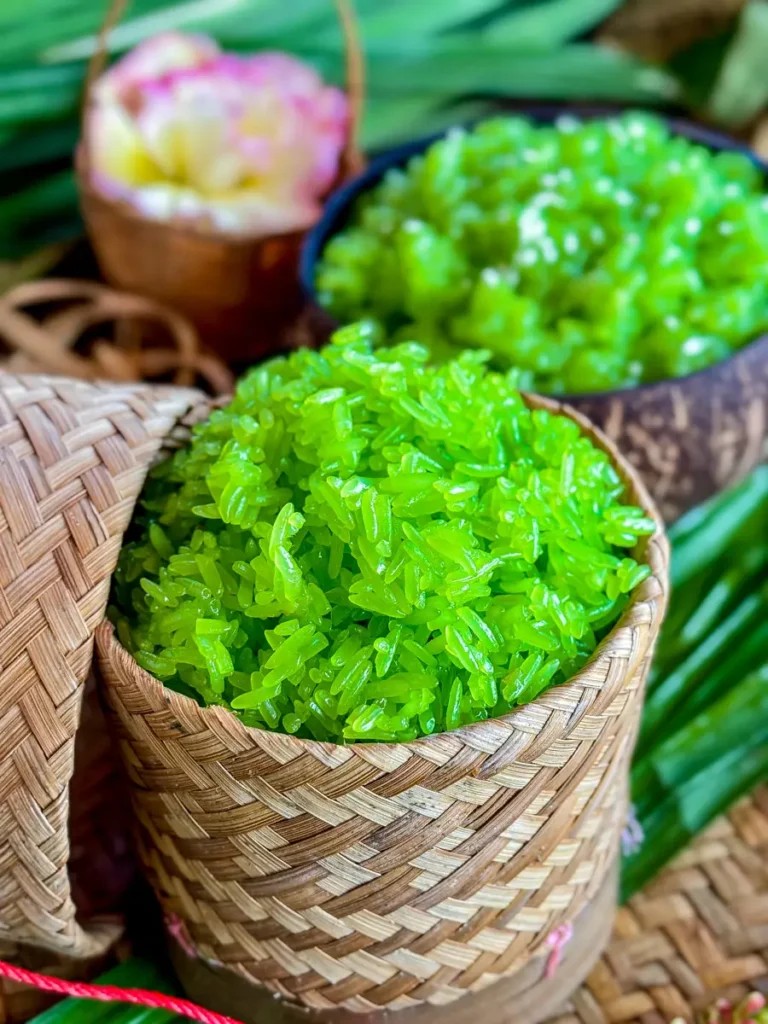 Freshly made pandan sticky rice in a woven bamboo container.
