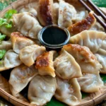Pork gyoza with sauce on a traditional bamboo-woven dish.