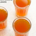 three glasses filled with sulaimani chai on a cream background.