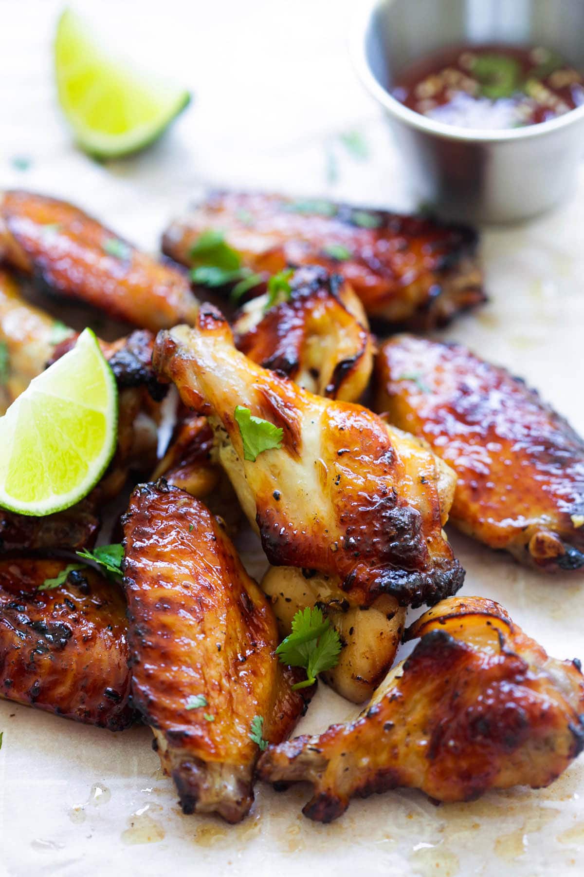 Sweet chili chicken wings served with Thai sweet chili sauce and fresh lime wedges.