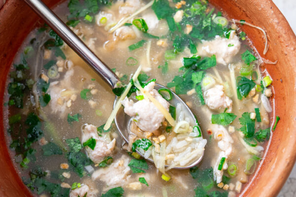 Thai chicken rice soup (Khao Tom Gai) in a bowl.