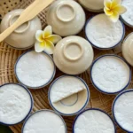 Thai coconut pudding, kanom tuay, in small ceramic bowls.