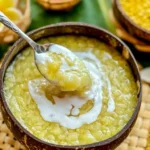 Mung bean pudding, Thai tau suan dessert with coconut cream, served in a coconut bowl and scooped with a spoon.