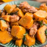 Thai pumpkin stir fry with chicken and Thai basil on a green ceramic plate.