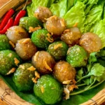 Thai tapioca dumplings with savory pork filling, lettuce, and herbs, ready to serve as a traditional Thai snack.