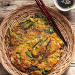 Crispy yachaejeon served on a woven basket plate
