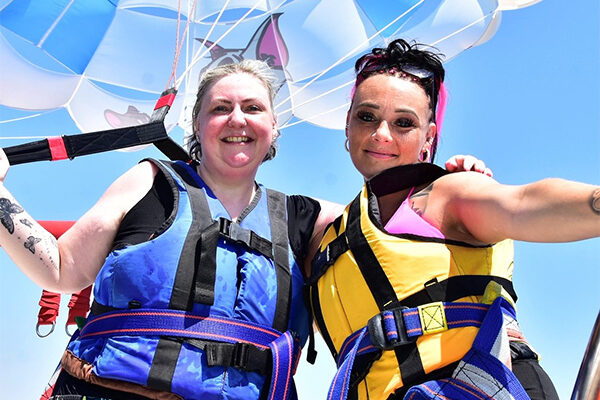11 summer activity ideas for you to try? Slimming World member Becs posing next to her niece with a colourful parachute behind them – one of Slimming World's 11 summer activity ideas