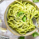 bowl with pesto pasta garnished with fresh basil Parmigiano-Reggiano