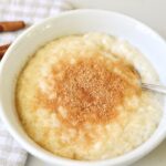 bowl with German rice pudding sprinkled with sugar and cinnamon powder