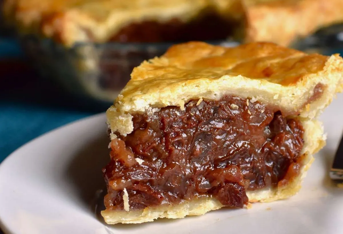 Delicious slice of homemade raisin pie with flaky crust, ready to enjoy.