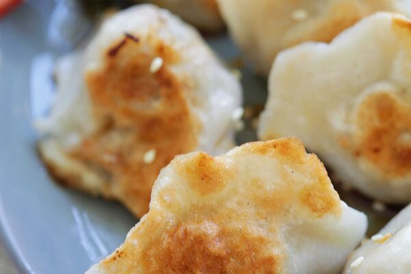 Chinese style pan fried dumplings served on a plate.