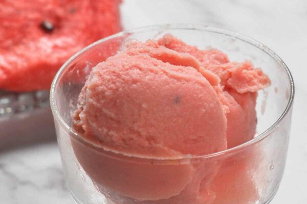 Watermelon Ice cream scooped in a glass container.