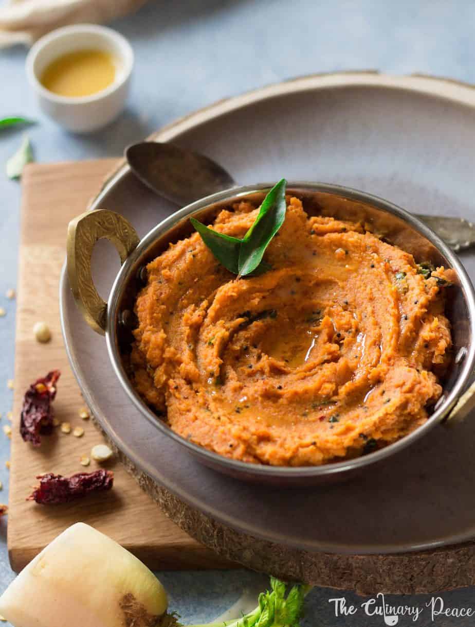 Radish Chutney – The Culinary Peace 1 Orange coloured radish or moolangi chutney served in a bowl with curry leaves and placed against a light background